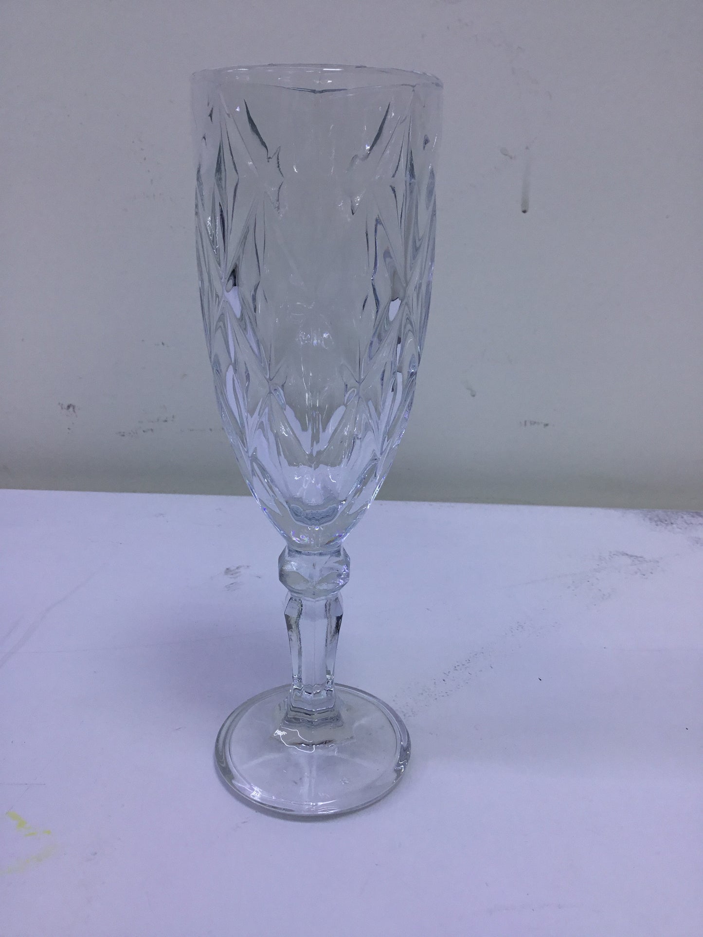 Clear glass goblet with intricate patterns on a white background
