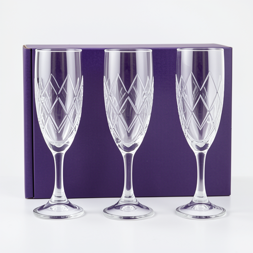 Three crystal champagne flutes with geometric patterns in a purple box on a white background